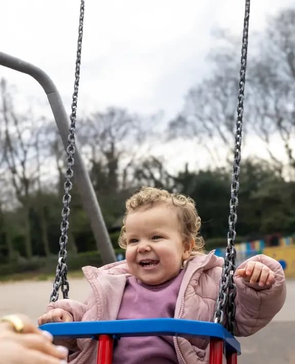 A young child on a swing in a childrens playground