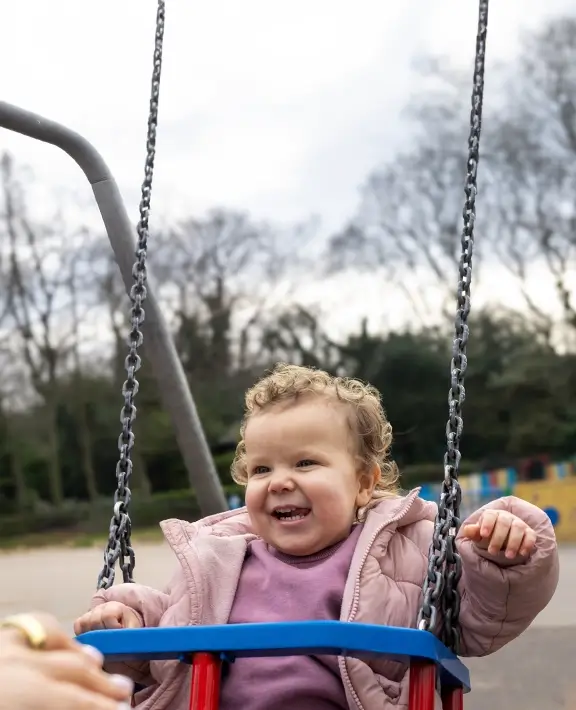 A young child on a swing in a childrens playground
